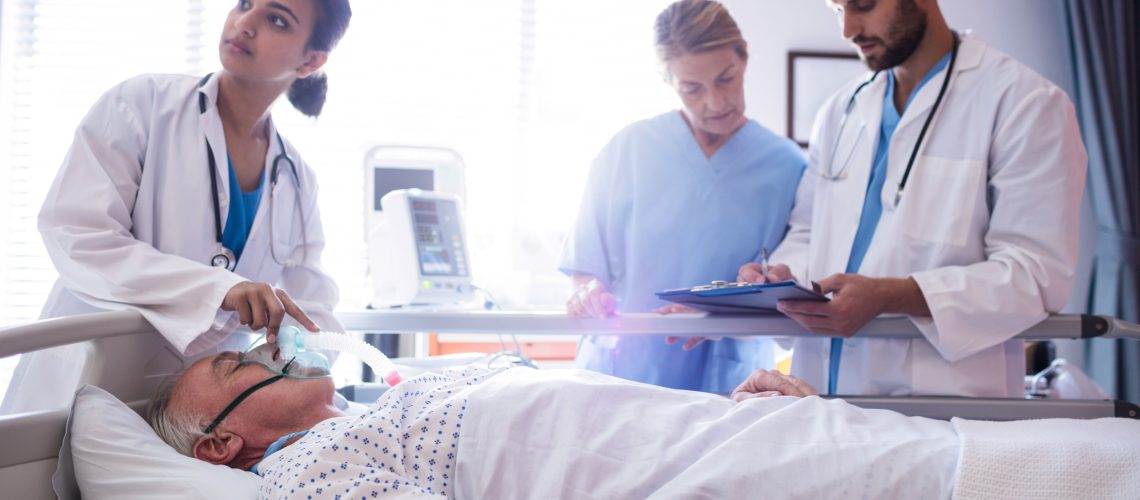 Female doctor putting oxygen mask on patient face in the hospital