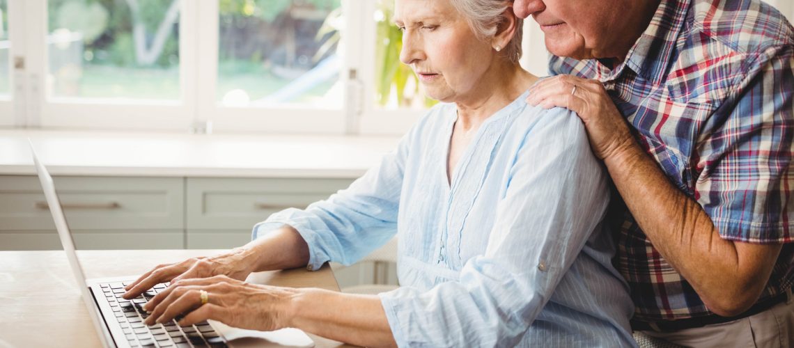 Senior couple using laptop at home