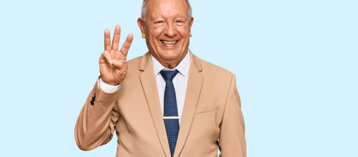 Senior caucasian man wearing business suit and tie showing and pointing up with fingers number three while smiling confident and happy.