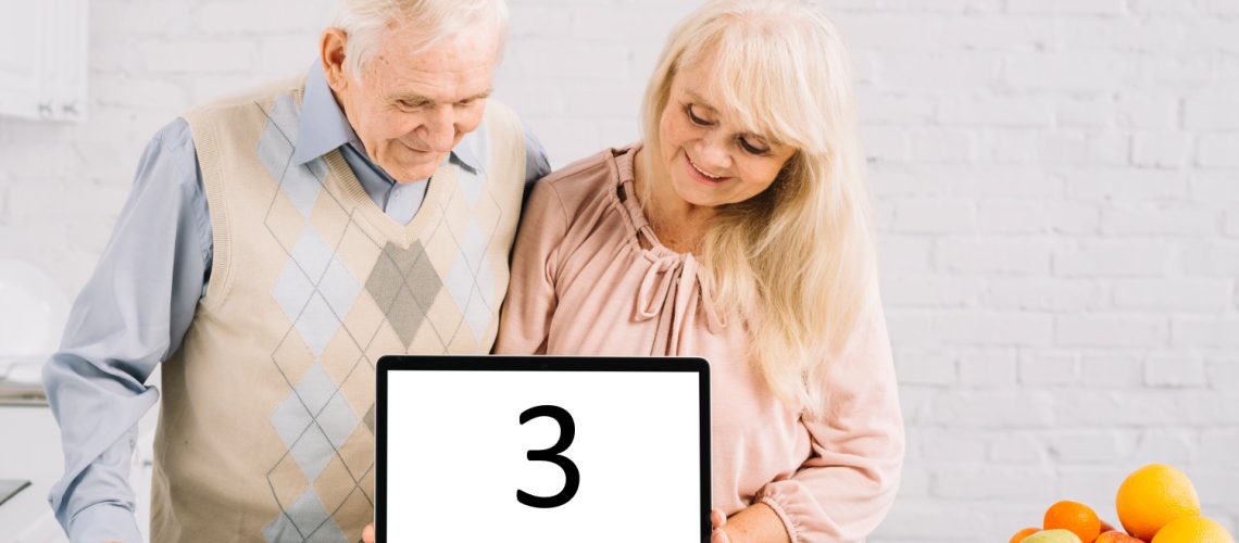 senior-couple-with-laptop-kitchen